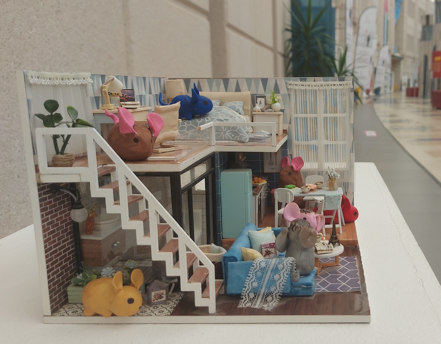 A small model of a mice house with colorful mice is sitting on a table in the Atrium on the Dubai Campus in May 2023.